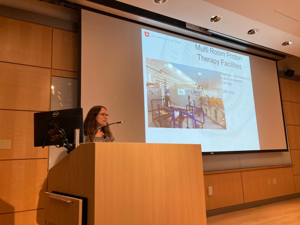 Sara St. James behind podium with projector slides in background