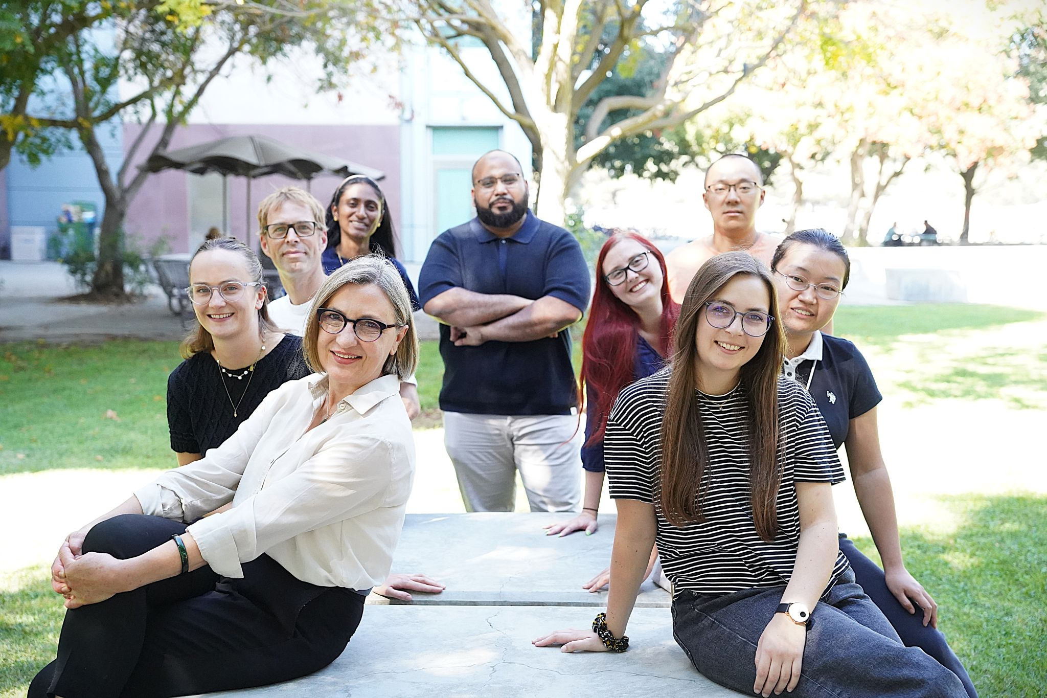 Marcu and members of her lab pose for a photo at an outdoor table