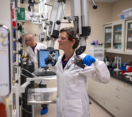 A scientist in a lab coat conducts research with laboratory equipment.