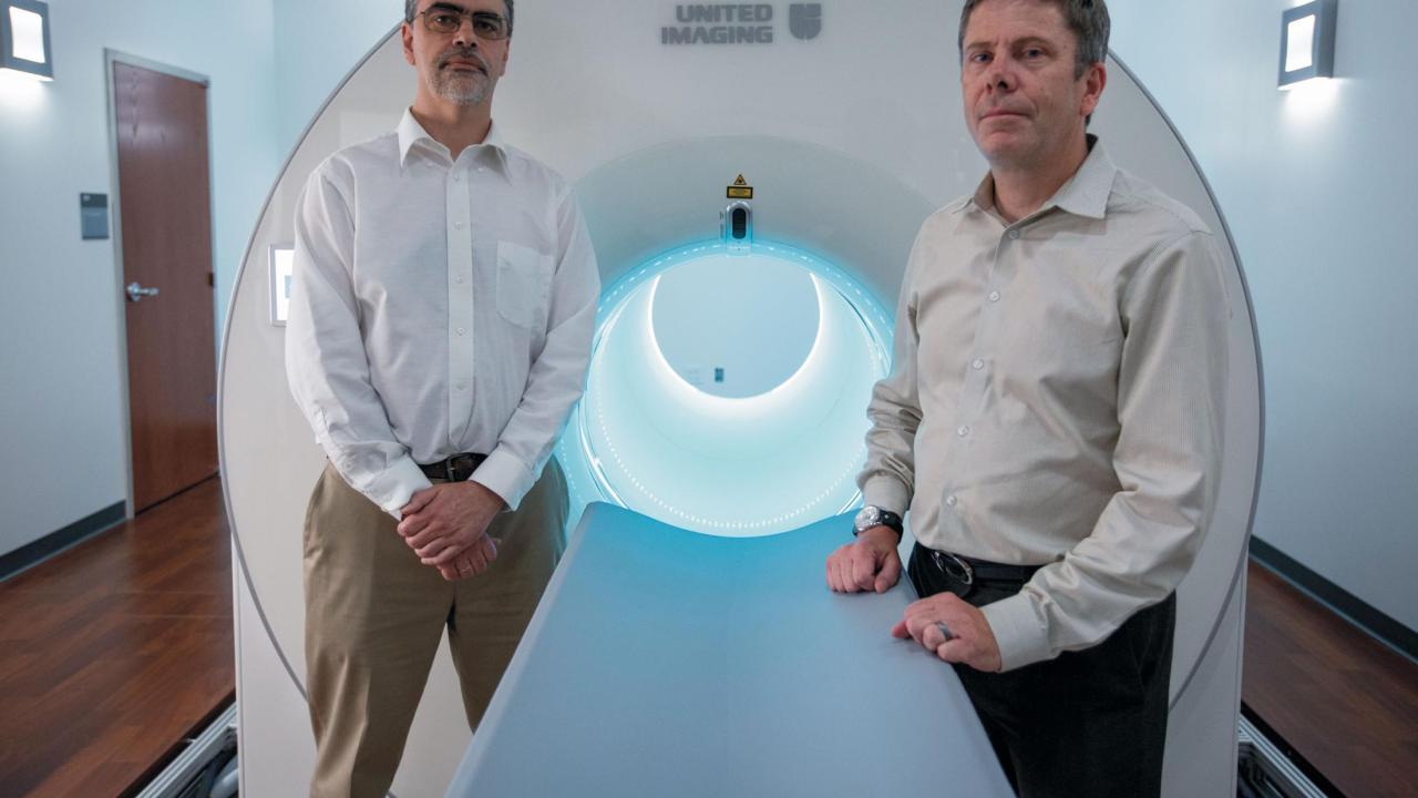 Ramsey Badawi and Simon Cherry pose in front of EXPLORER