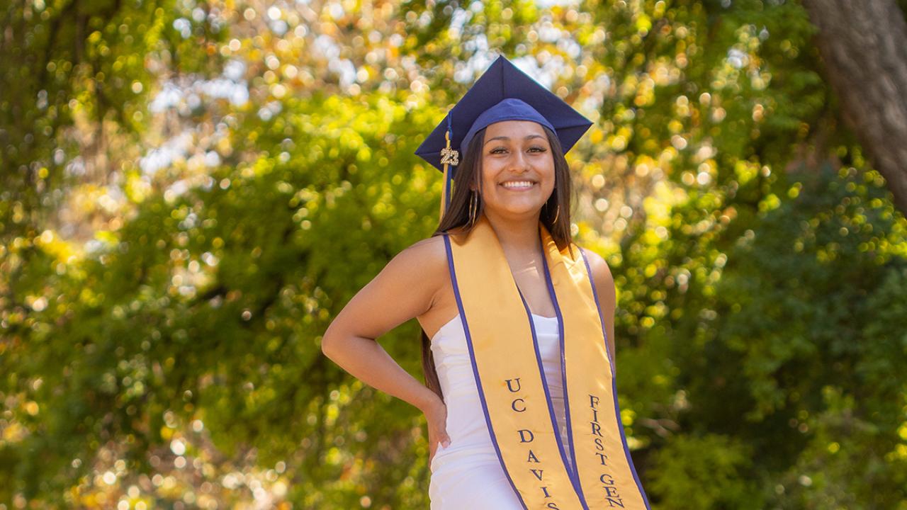 Blanca Osorio sitting on sculpture of an egg head on the UC Davis campus