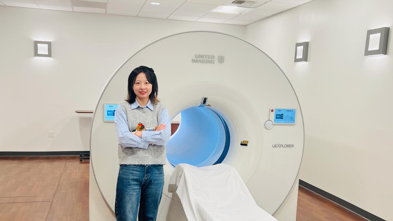 Xiaoyu Duan stands before a uEXPLORER total-body PET scanner