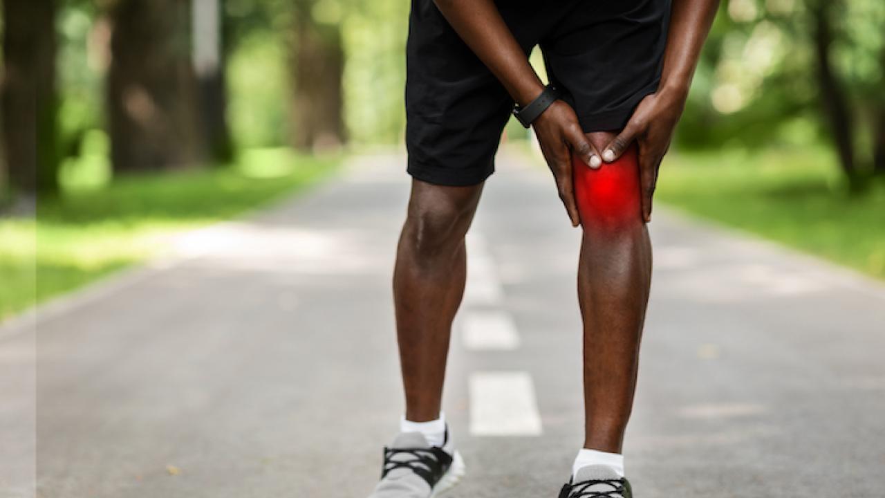 sportsman touching his inflamed knee