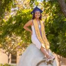 Blanca Osorio sitting on sculpture of an egg head on the UC Davis campus