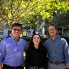 Three people stand outdoors