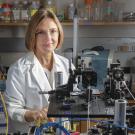 Dr. Marcu in a white lab coat by a table of imaging equipment