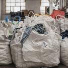 Piles of clothes in large bags